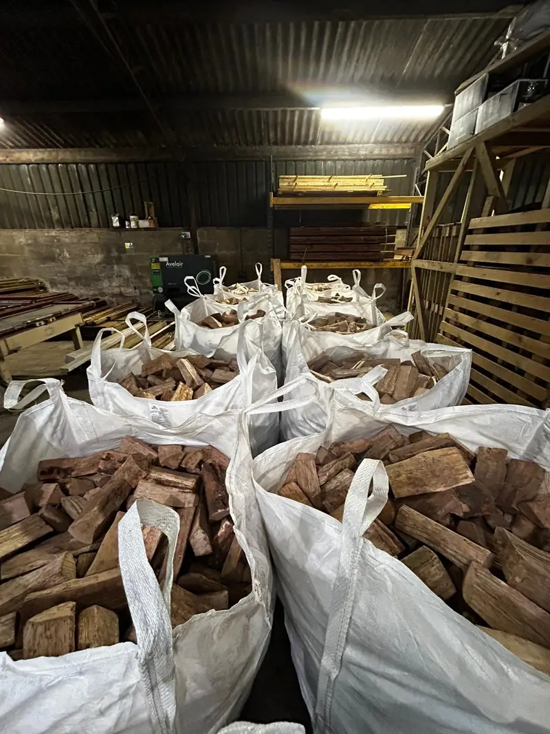Stacked kiln-dried hardwood logs showing the end-grain cross sections